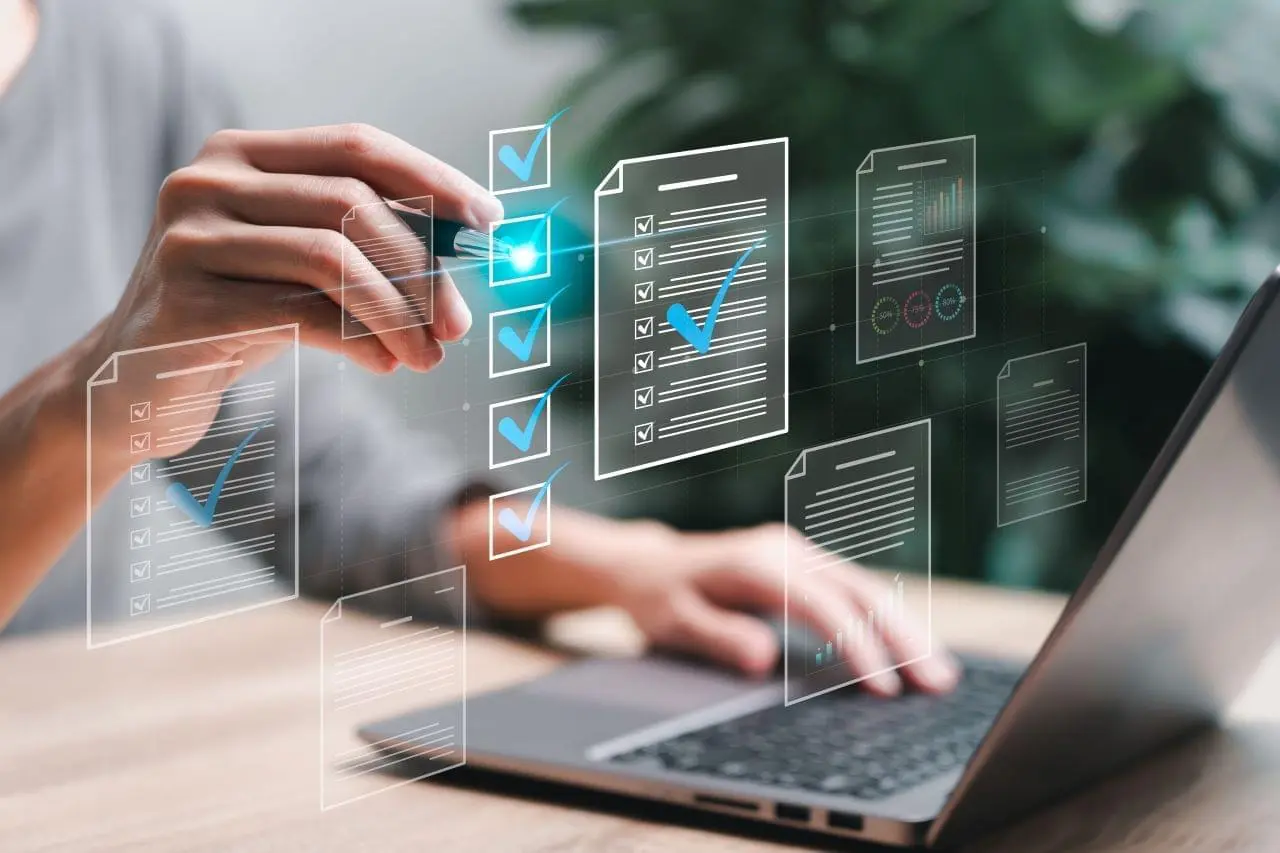 Person clicking on checkmarks while working on a laptop
